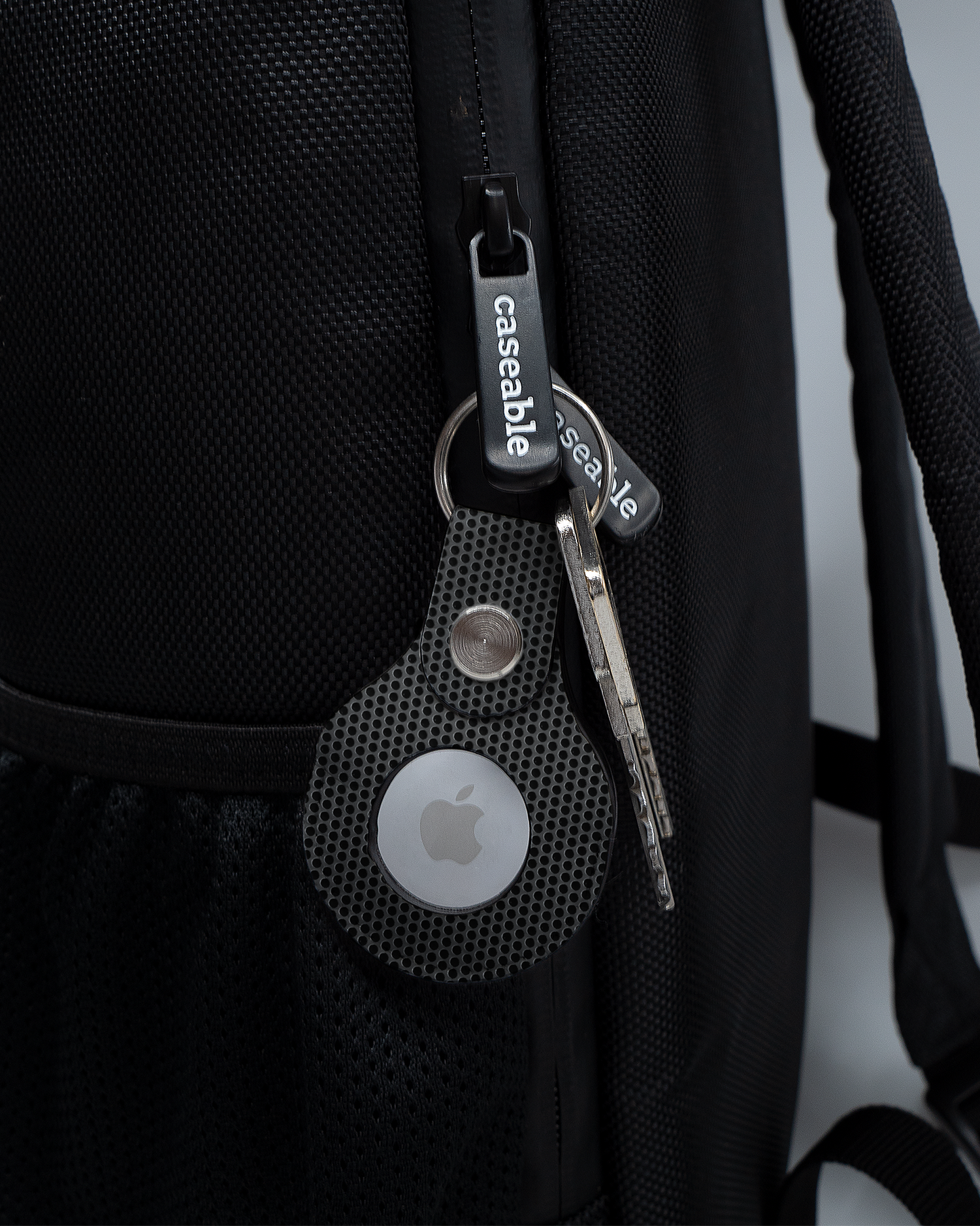 AirTag Holder with design Carbon II attached to a bag