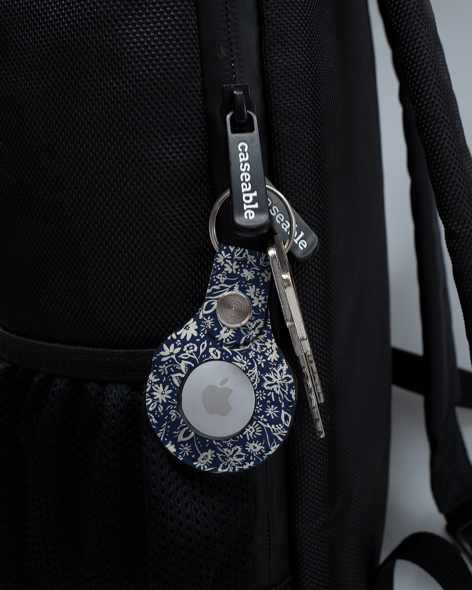 AirTag Holder with design Ditsy Blue Paisley attached to a bag