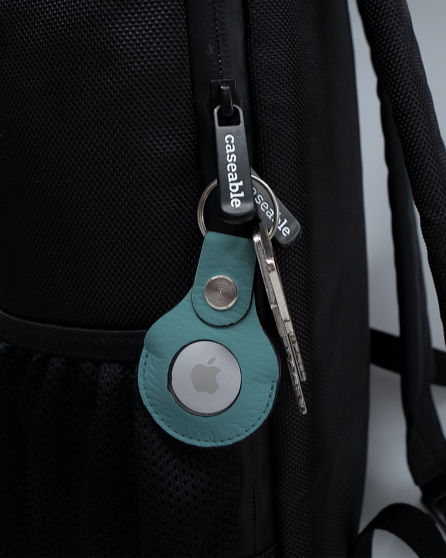 AirTag Holder with design TURQUOISE attached to a bag