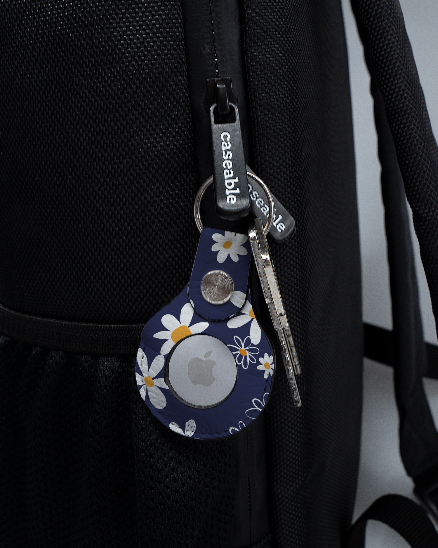AirTag Holder with design Navy Daisies attached to a bag