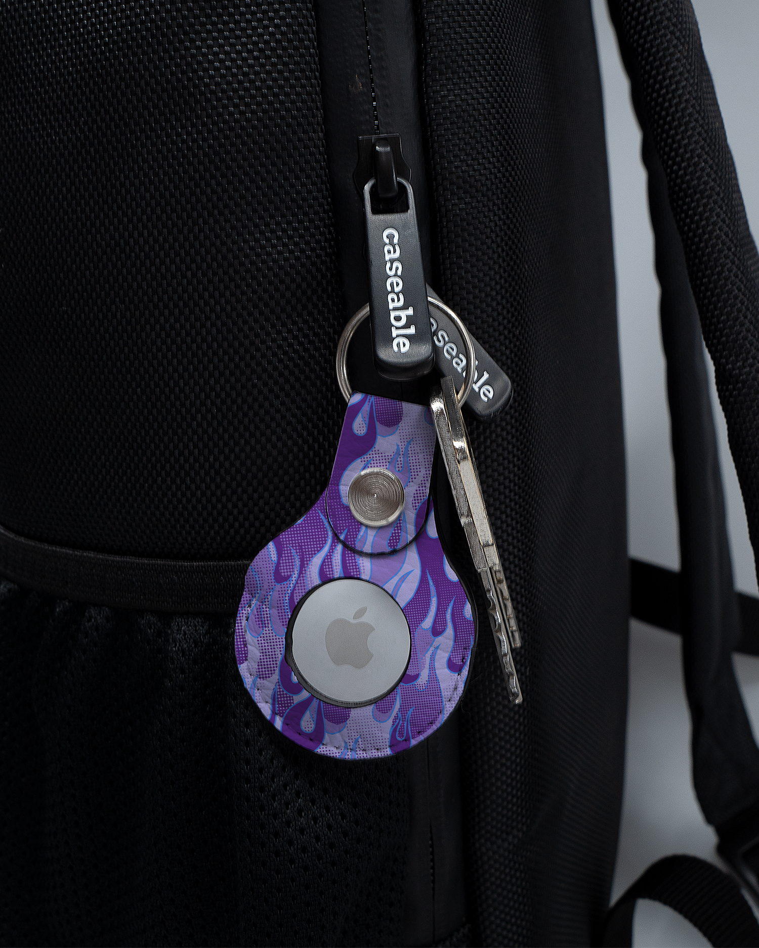 AirTag Holder with design Purple Flames attached to a bag