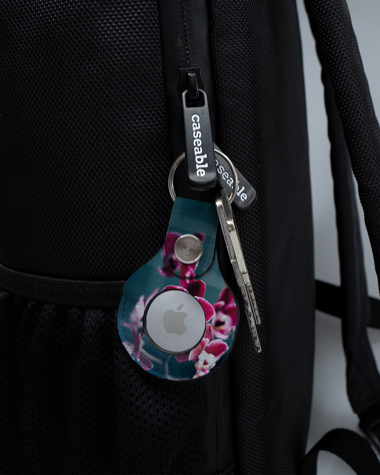 AirTag Holder with design Orchid attached to a bag