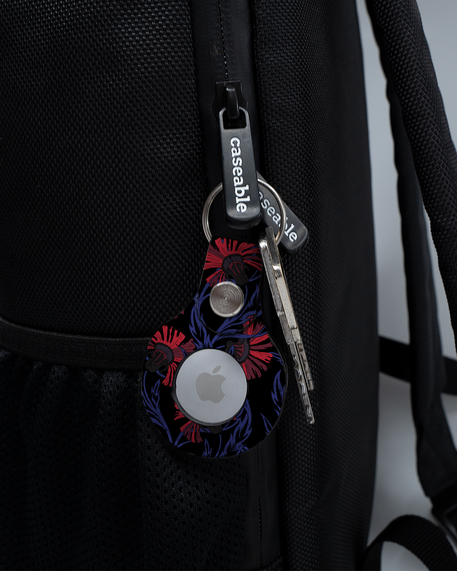 AirTag Holder with design Midnight Floral attached to a bag