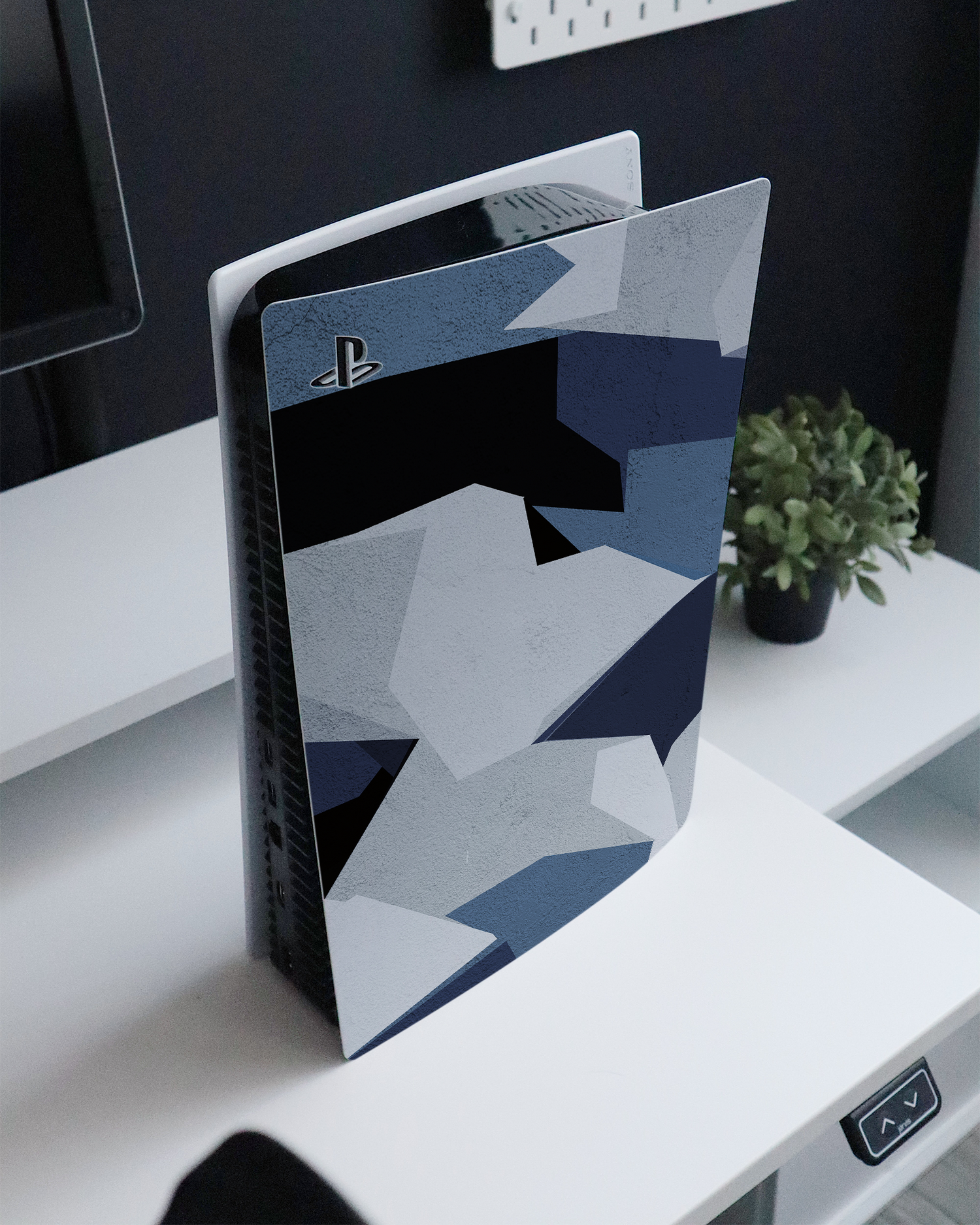 Geometric Camo Blue Console Skin for Sony PlayStation 5 Digital Edition standing on a sideboard 