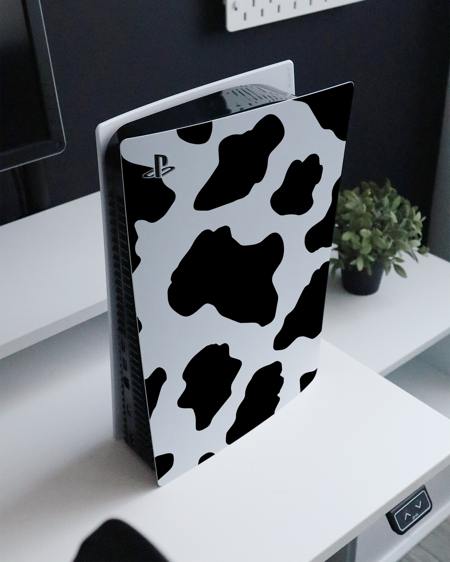 Cow Print 2 Console Skin for Sony PlayStation 5 Digital Edition standing on a sideboard 
