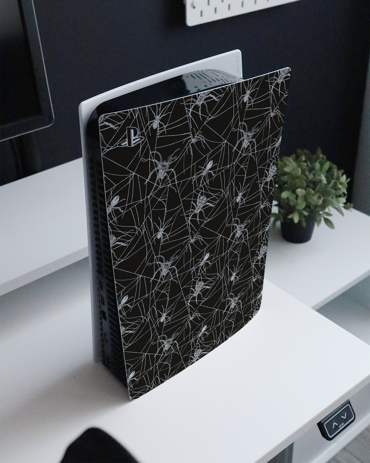 Spiders And Webs Console Skin for Sony PlayStation 5 standing on a sideboard 