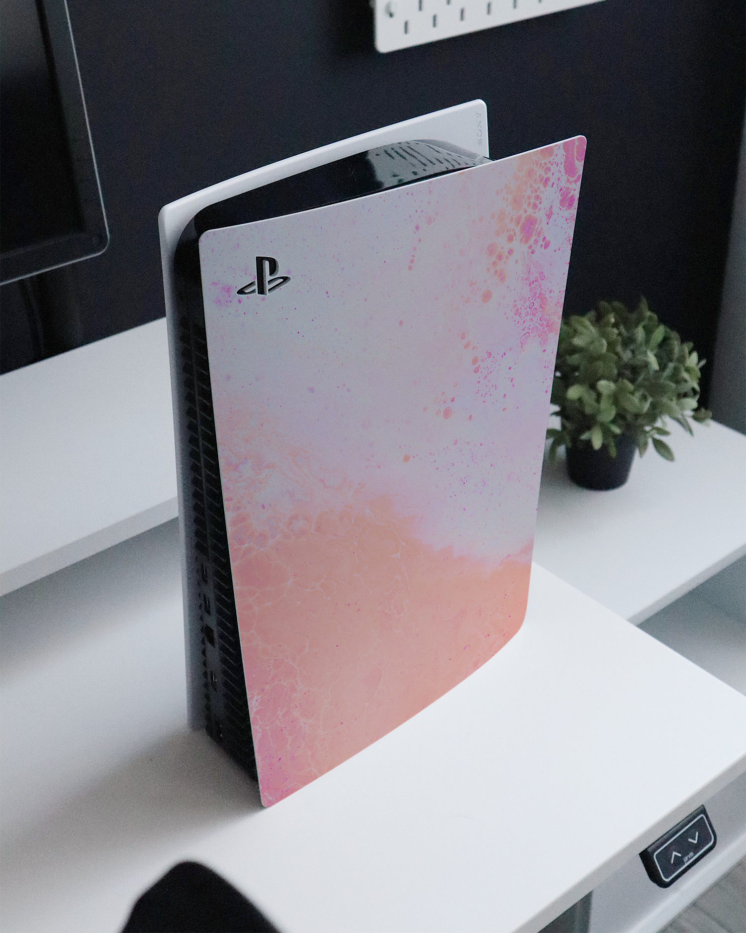 Peaches & Cream Marble Console Skin for Sony PlayStation 5 standing on a sideboard 