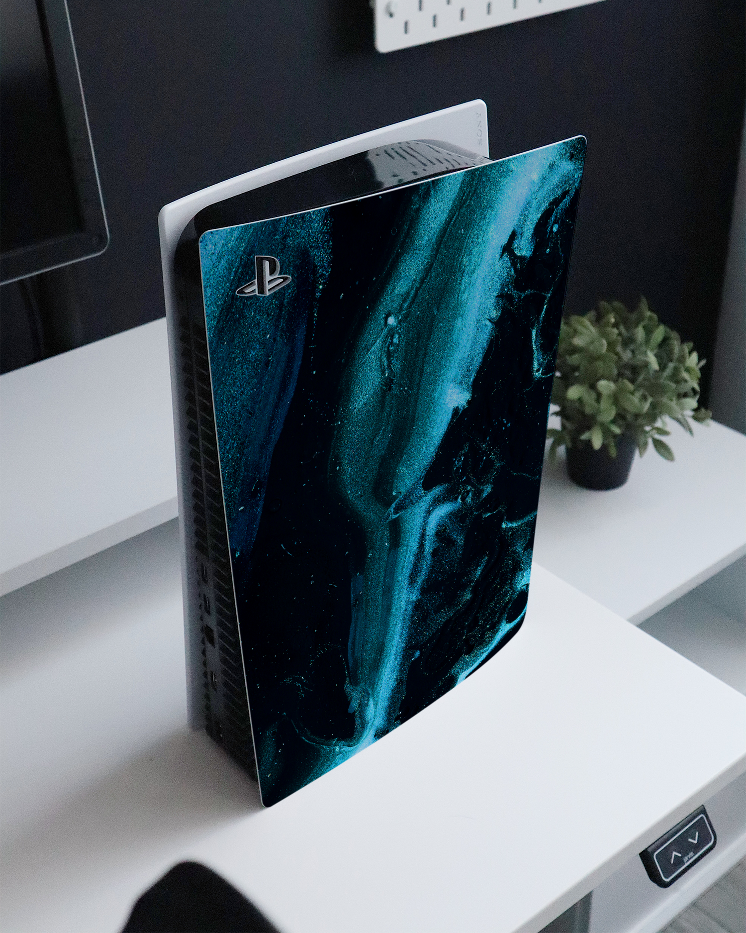 Deep Turquoise Sparkle Console Skin for Sony PlayStation 5 standing on a sideboard 