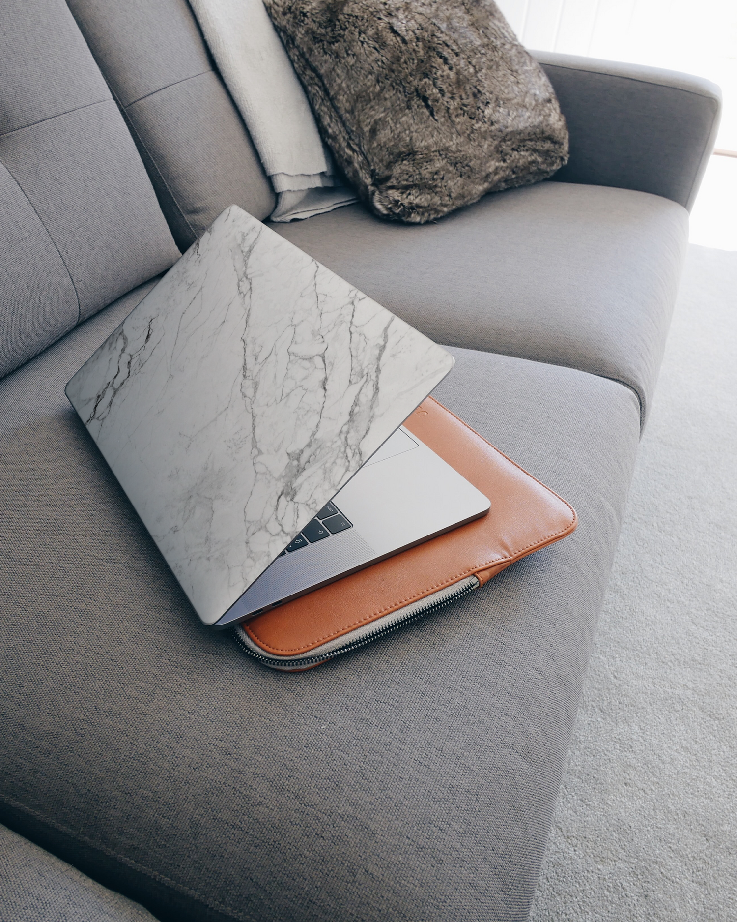 White Marble Laptop Skin for 15 inch Apple MacBooks on a couch