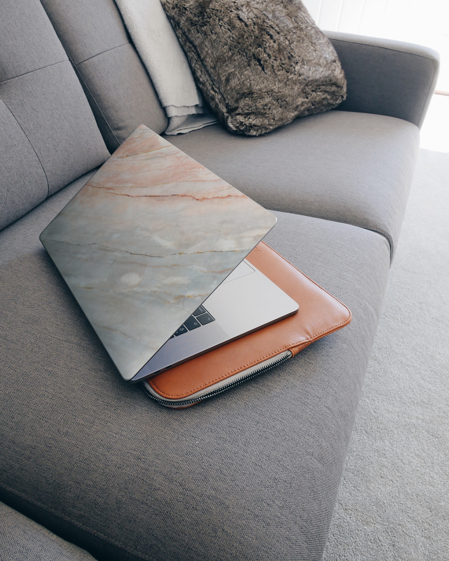 Mother of Pearl Marble Laptop Skin for 15 inch Apple MacBooks on a couch