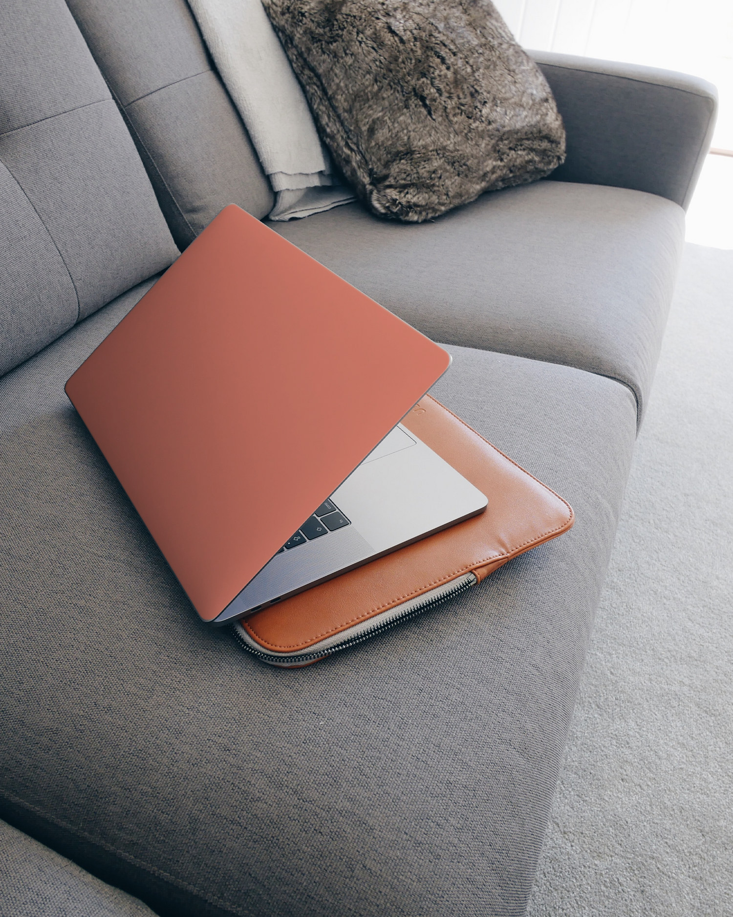 DEEP CORAL Laptop Skin for 15 inch Apple MacBooks on a couch