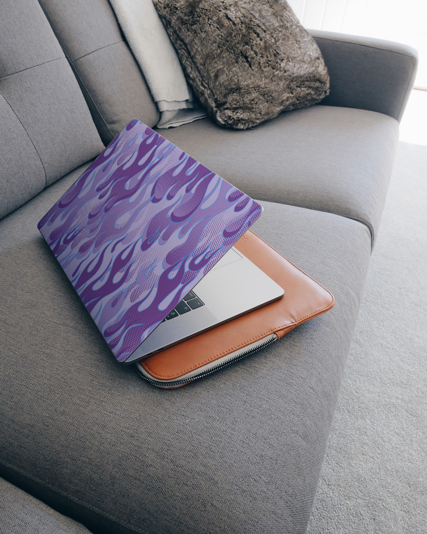 Purple Flames Laptop Skin for 15 inch Apple MacBooks on a couch