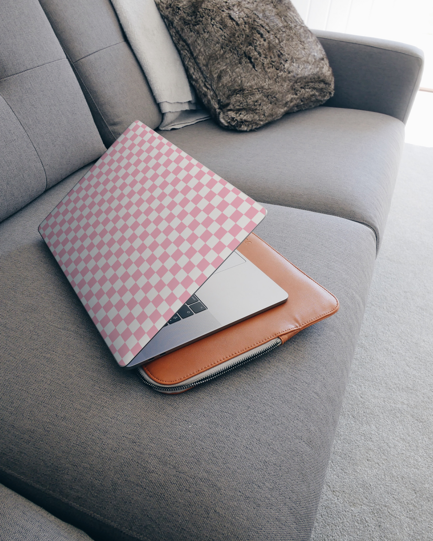 Pink Checkerboard Laptop Skin for 15 inch Apple MacBooks on a couch
