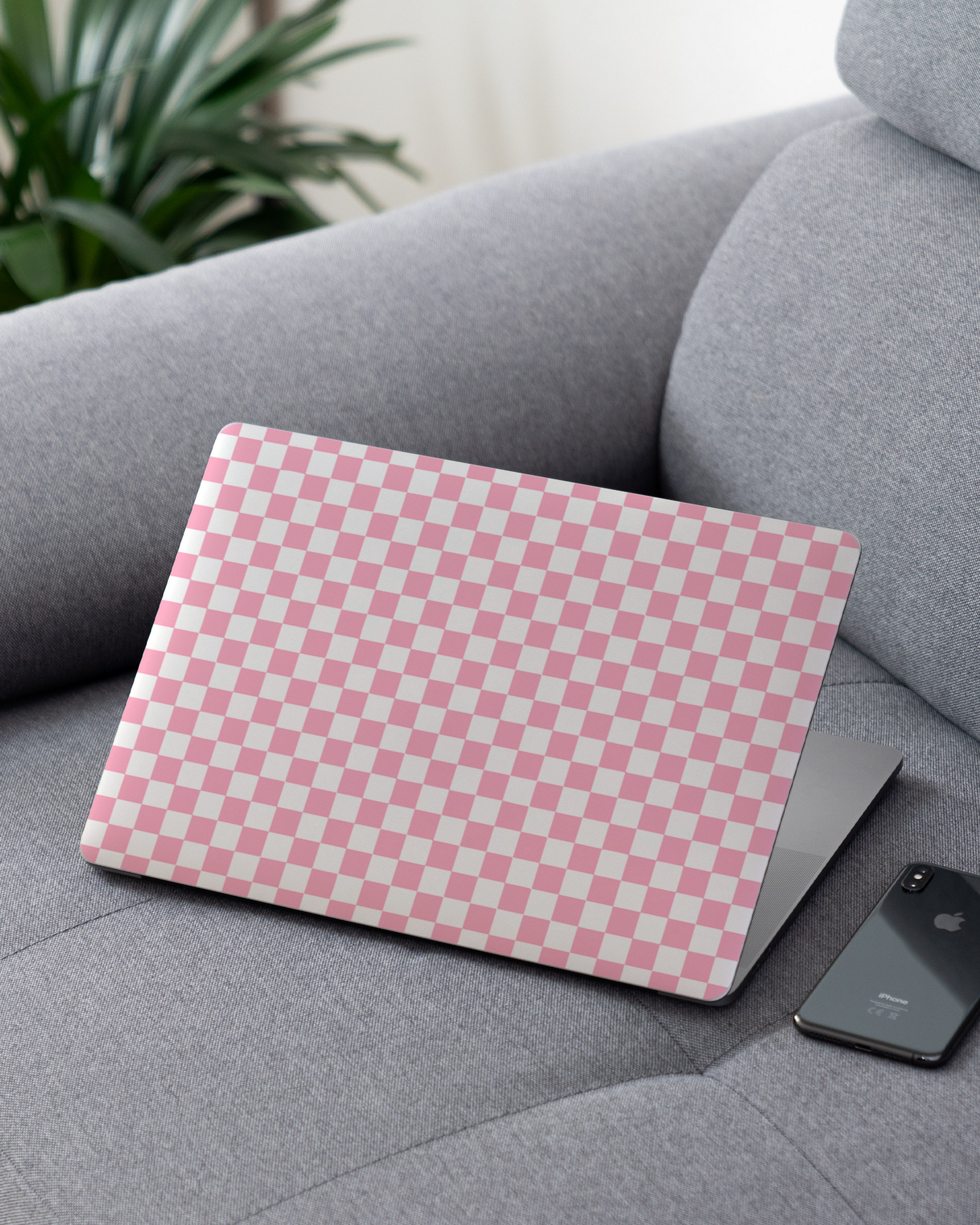 Pink Checkerboard Laptop Skin for 13 inch Apple MacBooks on a couch